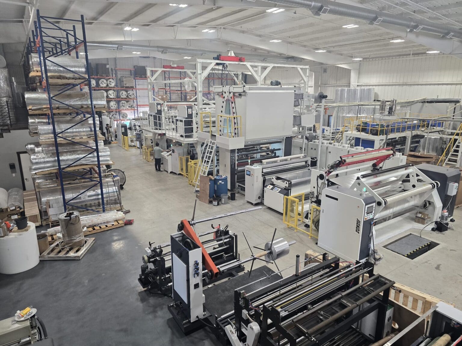 IIP production floor in Rhome, Texas — converting and laminating lines with finished reflective insulation rolls